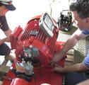 two workers performing laser shaft alignment on pump component