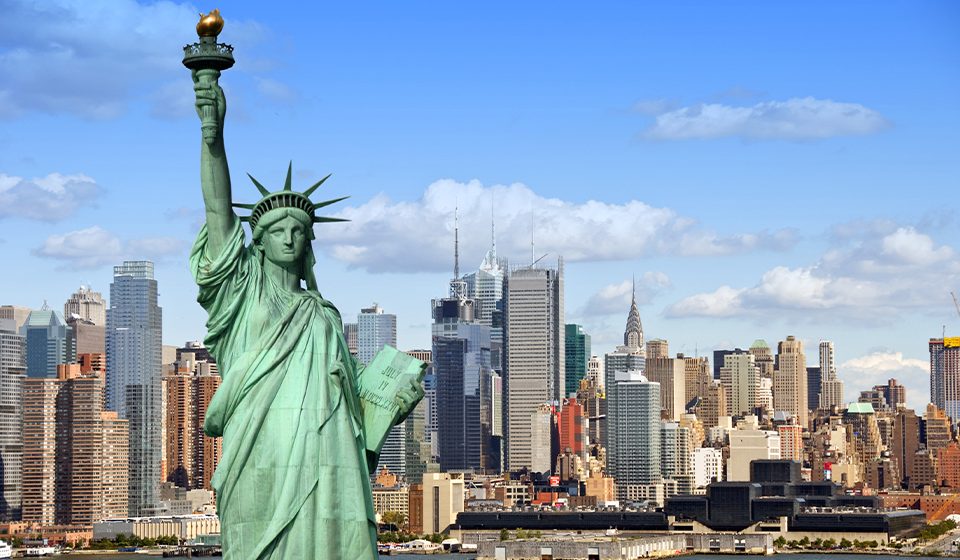 new york city skyline view with statue of liberty in front
